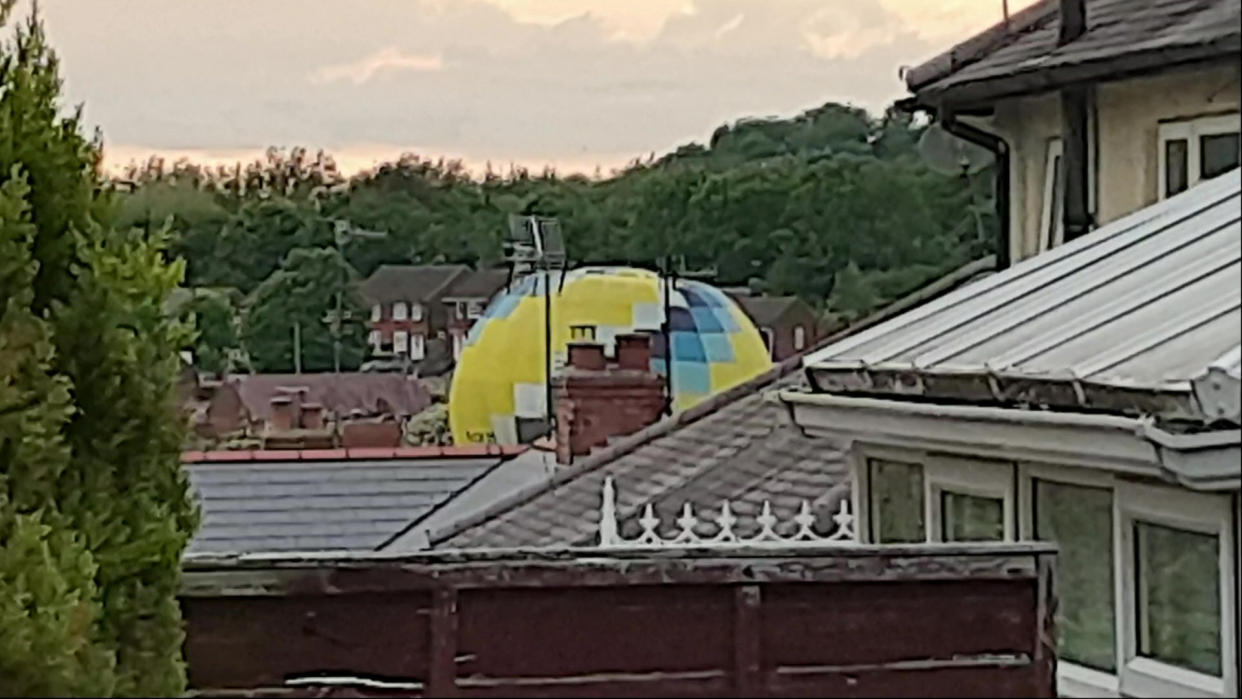 Video grab of  the moment a hot air balloon accidentally landed in a residential housing estate. (SWNS)