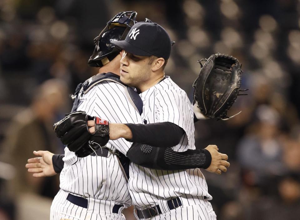 CHANGES TO RELIEF PITCHER NOT STARTING PITCHER - New York Yankees catcher Brian McCann, left, congratulates relief pitcher David Phelps after Phelps closed out the Yankees' 4-1 victory over the Boston Red Sox in a baseball game at Yankee Stadium in New York, Thursday, April 10, 2014. (AP Photo/Kathy Willens)