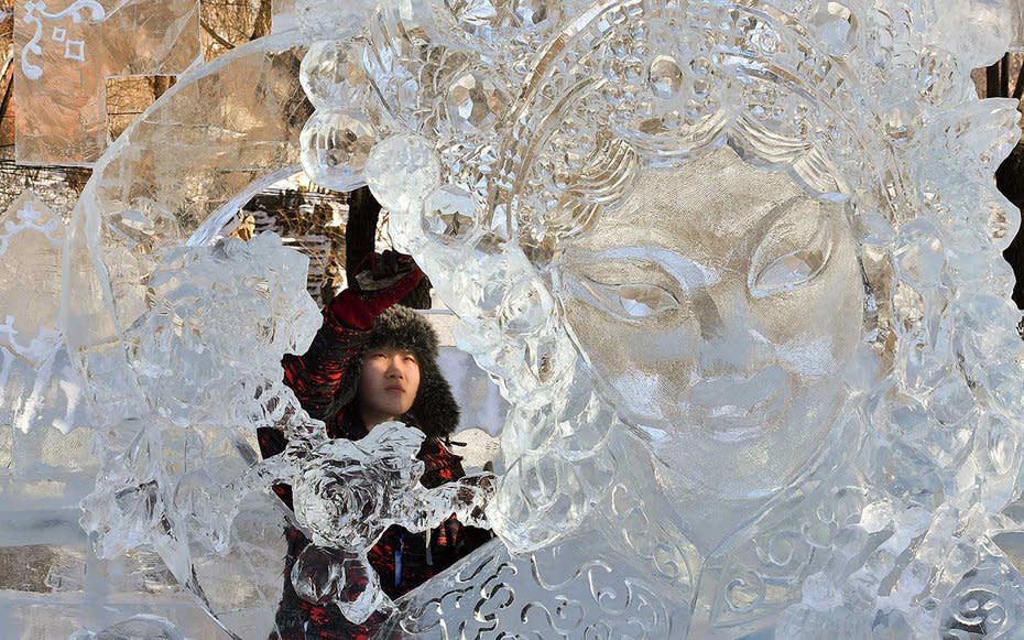 <p>A participant carves an ice sculpture during a national ice sculpture contest.</p>