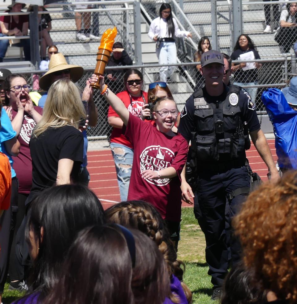 Carrying a plastic torch, student-athlete Abigail Barber wove through the crowd as she prepared to kick off the Inaugural Hesperia Unified School District Special Olympic School Games at Oak Hills High Schoo on Friday, May 10, 2024.
