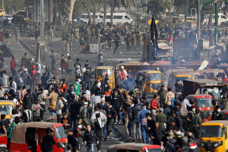 Demonstrators clash with members of Iraqi security forces during ongoing anti-government protests, in Baghdad