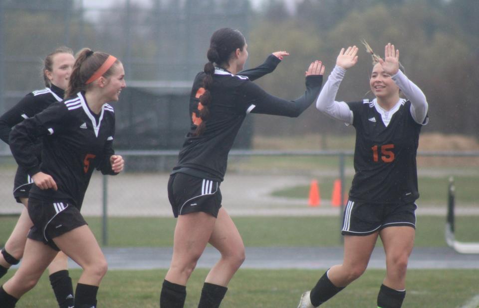 Cheboygan senior Kenzie Burt (3) gets congratulated by fellow senior Cassidy Jewell (15) and teammates after scoring during the first half of a girls soccer matchup against Shepherd at home on Friday.