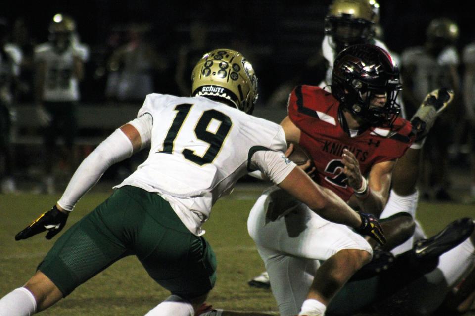 Creekside quarterback Sean Ashenfelder (2) tries to escape Fleming Island's Cohen Cioffi (19).