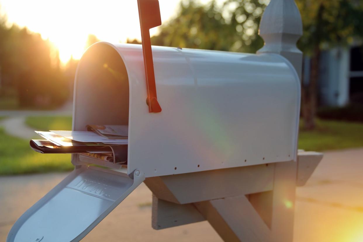 open mail box with a pile of letters and newspapers