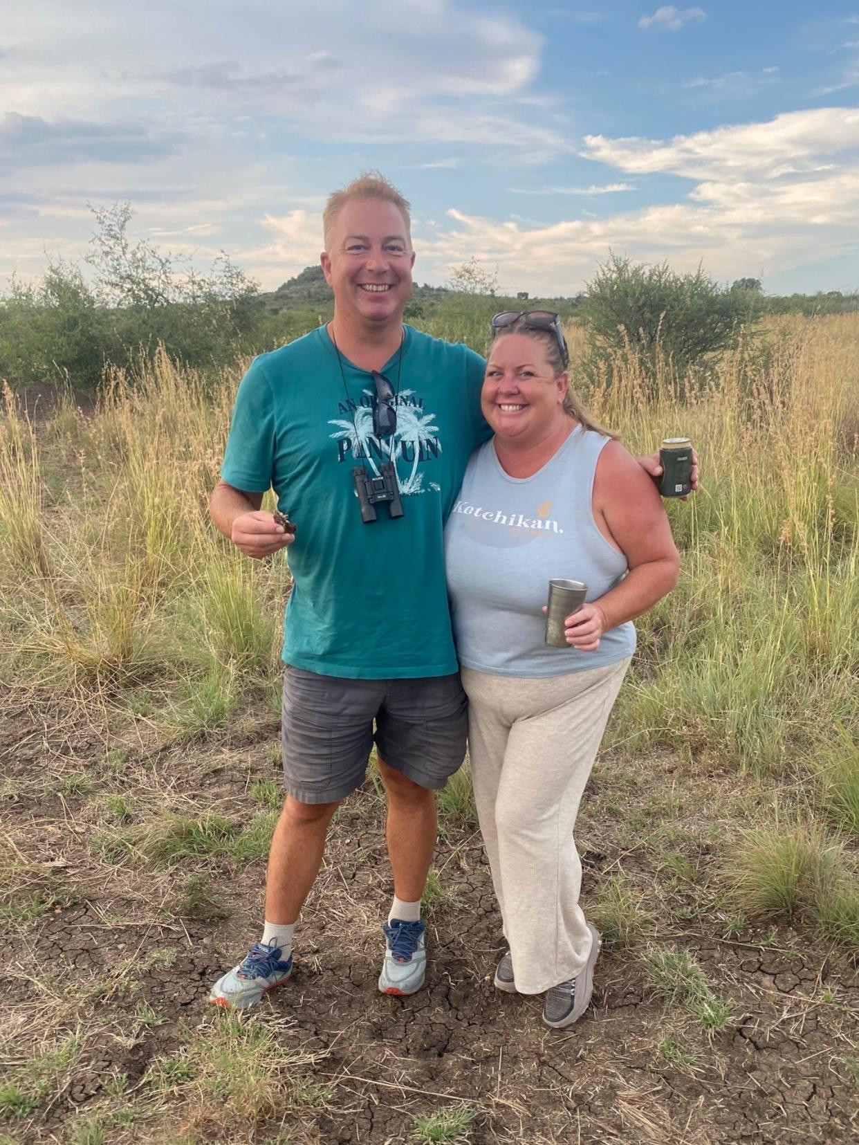 The author and her spouse posing for a photo and smiling with drinks in their hands.