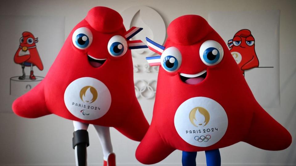 Actors model life-size versions of Les Phryges, the two mascots for the Paris Olympic and Paralympic Games