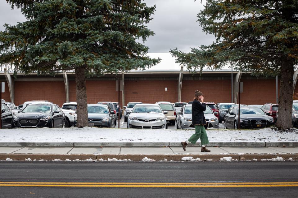 A student walks past the fieldhouse at Northern Arizona University on the first day of snow on Oct. 12, 2021.