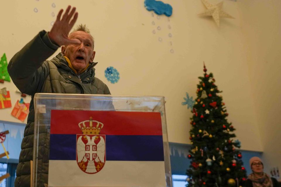 A man gestures after voting during a parliamentary and local election at a polling station in Belgrade, Serbia, Sunday, Dec. 17, 2023. The vote in Serbia pits Serbian President Aleksandar Vucic's governing Serbian Progressive Party, or SNS, against a pro-Western opposition coalition which is trying to undermine the firm grip on power the populists have maintained since 2012. (AP Photo/Darko Vojinovic)