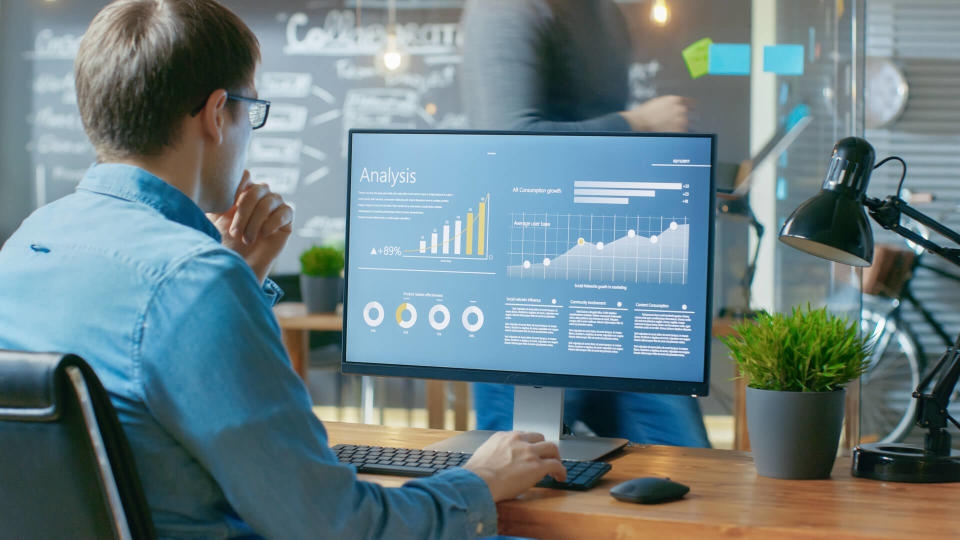 Analyst Works on a Personal Computer Showing Statistics, Graphs and Charts.