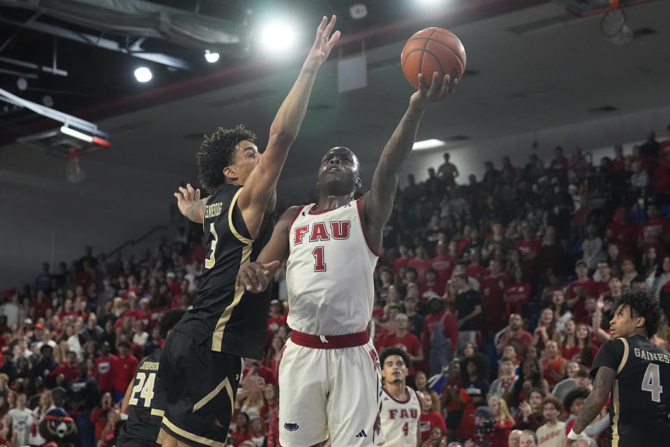 Florida Atlantic guard Johnell Davis (1) drives to the basket as UAB forward Yaxel Lendeborg (3)defends during the first half of an NCAA college basketball game, Sunday, Jan. 14, 2024, in Boca Raton, Fla. (AP Photo/Marta Lavandier)