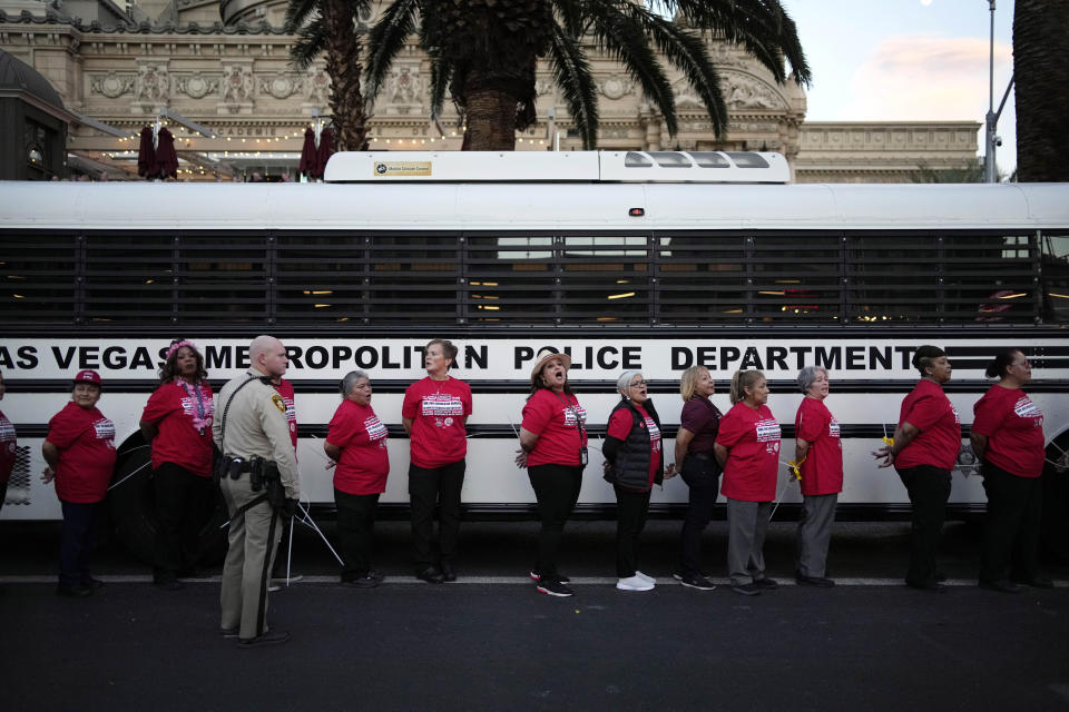 Members of the Culinary Workers Union are detained by Las Vegas police along the Strip, Wednesday, Oct. 25, 2023, in Las Vegas. Thousands of hotel workers fighting for new union contracts rallied Wednesday night on the Las Vegas Strip, where rush-hour traffic was disrupted when some members blocked the road before being detained by police. (AP Photo/John Locher)