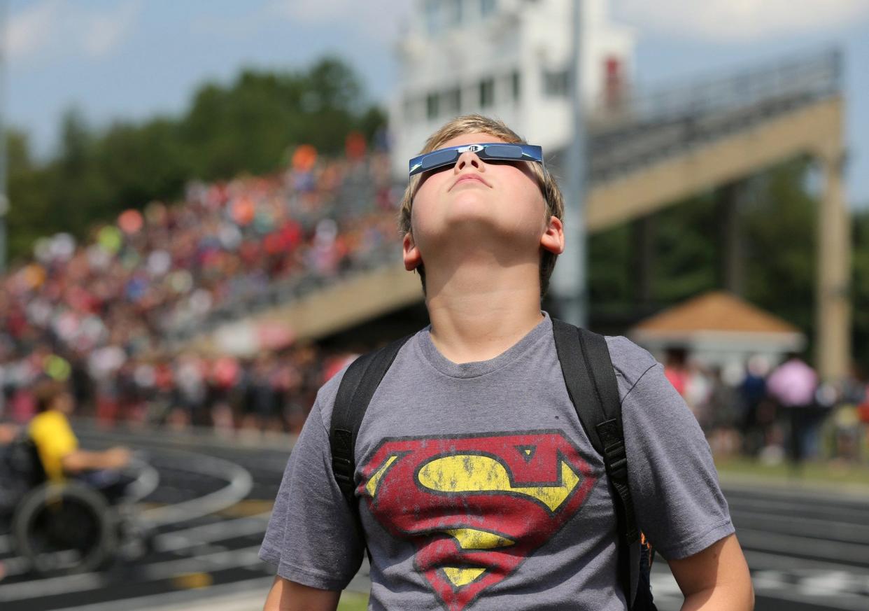 Stanton Middle School sixth-grade student Trenten Falkenberg, 11, focuses on the partial eclipse in 2017 during a gathering of students at the football stadium in Kent.