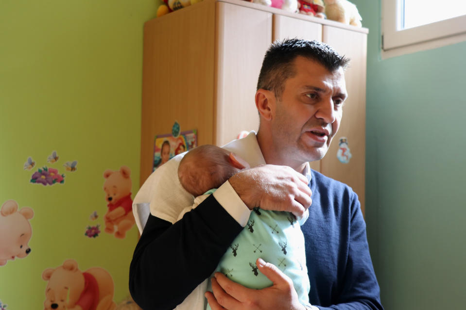 Serbian Minister of Labor, Employment, Veterans' Affairs and Social Affairs Zoran Djordjevic carries baby Stefan in his arms.