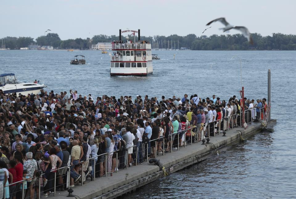 In this Saturday, July 27, 2019 photo, people watch a concert while they attend the second day of Tirgan summer festival by the lake Ontario at the Harbourfront Centre in Toronto, Canada. The event aims to preserve and celebrate Iranian and Persian culture, said festival CEO Mehrdad Ariannejad. Among those who attended were second-and third-generation immigrants, many of whom have never been to Iran or have not been there since leaving the country following the 1979 Islamic Revolution. (AP Photo/Kamran Jebreili)