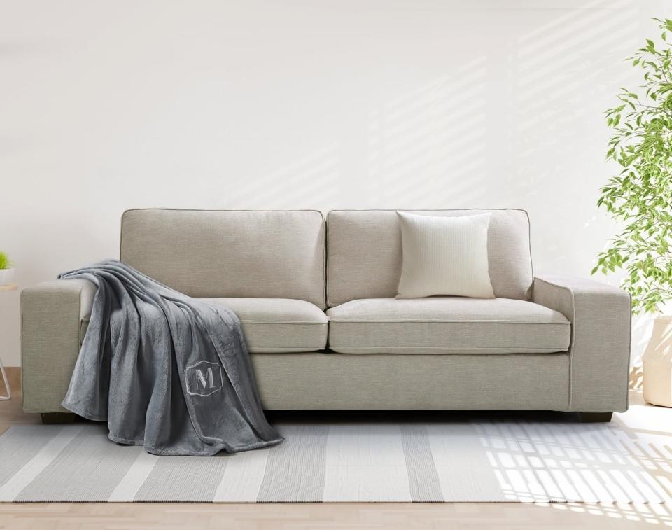 a beige sofa on a stripe carpet