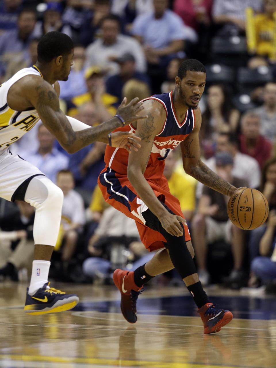 Washington Wizards forward Trevor Ariza, right, drives past Indiana Pacers forward Paul George during the first half of game 5 of the Eastern Conference semifinal NBA basketball playoff series Tuesday, May 13, 2014, in Indianapolis. (AP Photo/Darron Cummings)