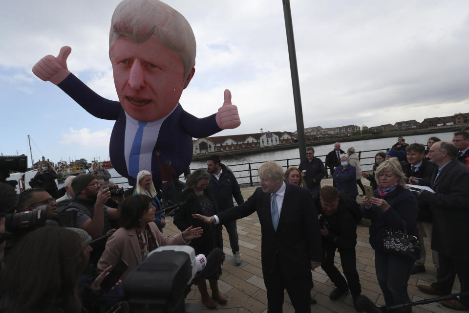 FILE - British Prime Minister Boris Johnson speaks to the media next to a large inflatable of him, after Conservative Party candidate Jill Mortimer won the Hartlepool by-election, at Hartlepool Marina, in Hartlepool, north east England, Friday, May 7, 2021. The moving vans have already started arriving in Downing Street, as Britain's Conservative Party prepares to evict Johnson. Debate about what mark he will leave on his party, his country and the world will linger long after he departs in September. (AP Photo/Scott Heppell, File)