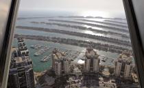 A portion of the Palm Jumeirah Island's frond villas and residential towers are seen from an observation deck of The View at The Palm Jumeirah, in Dubai, United Arab Emirates, Tuesday, April 6, 2021. Foreign buyers flush with cash have flooded the high-end property market in Dubai even as coronavirus vaccines roll out unevenly across the world and waves of infections force countries to extend restrictions. It's one of the few places in the world where they can dine, shop and do business in person. (AP Photo/Kamran Jebreili)