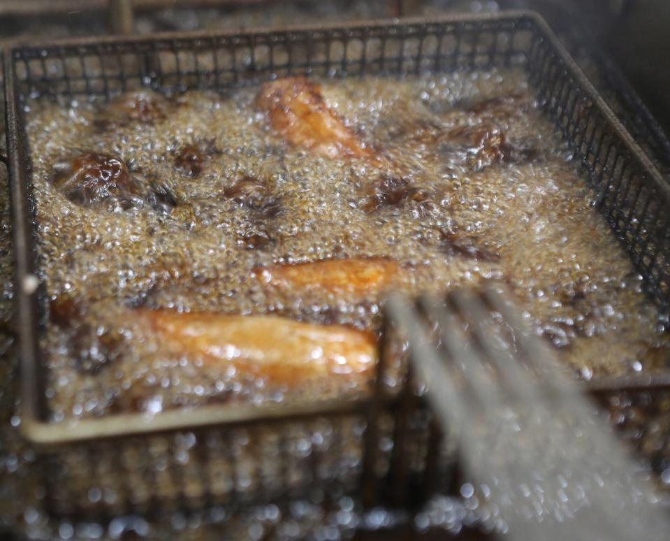 A basket of sausages cook in a deep fryer at Helen's Sausage House.