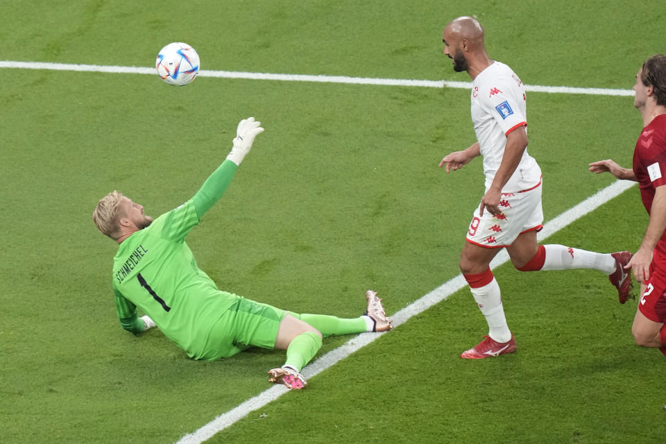 Tunisia's Issam Jebali, centre, misses a chance to score past Denmark's goalkeeper Kasper Schmeichel, left, during the World Cup group D soccer match between Denmark and Tunisia at the Education City Stadium in Al Rayyan, Qatar, Tuesday, Nov. 22, 2022. (AP Photo/Darko Bandic)