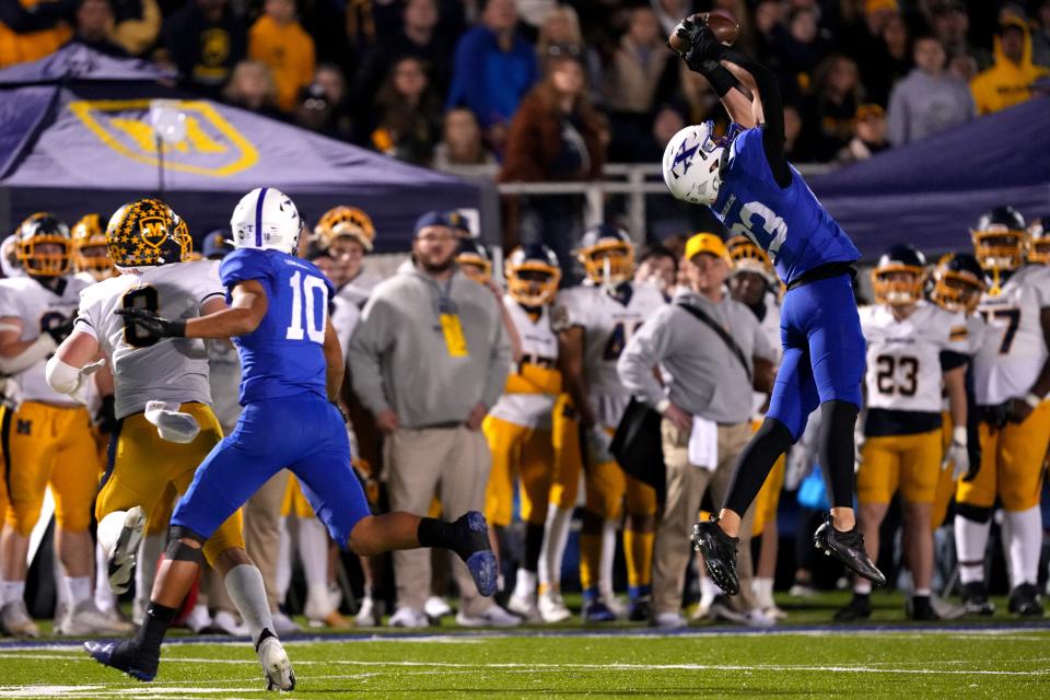 The moment: St. Xavier Bombers defensive back Brayden Reilly (23) intercepts a pass intended for Moeller Crusaders Eli Jacon Duffy (8) in the first half of a second-round Division I OHSAA high school football game, Friday, Nov. 3, 2023, at St. Xavier High School’s RDI Field in Cincinnati.