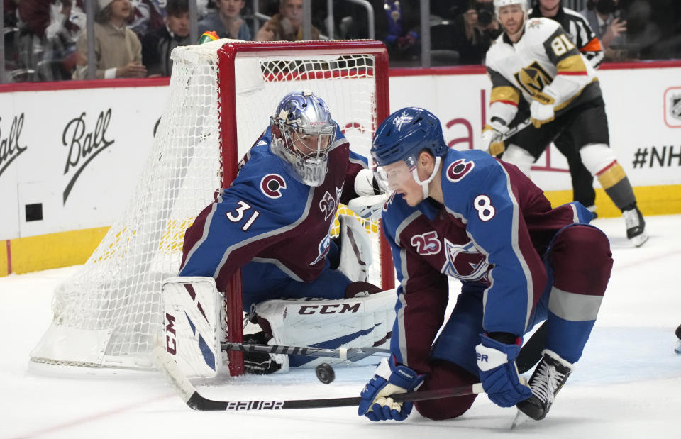 Colorado Avalanche defenseman Cale Makar, front, deflects a shot next to goaltender Philipp Grubauer during the first period of Game 5 of an NHL hockey Stanley Cup second-round playoff series against the Vegas Golden Knights on Tuesday, June 8, 2021, in Denver. (AP Photo/David Zalubowski)