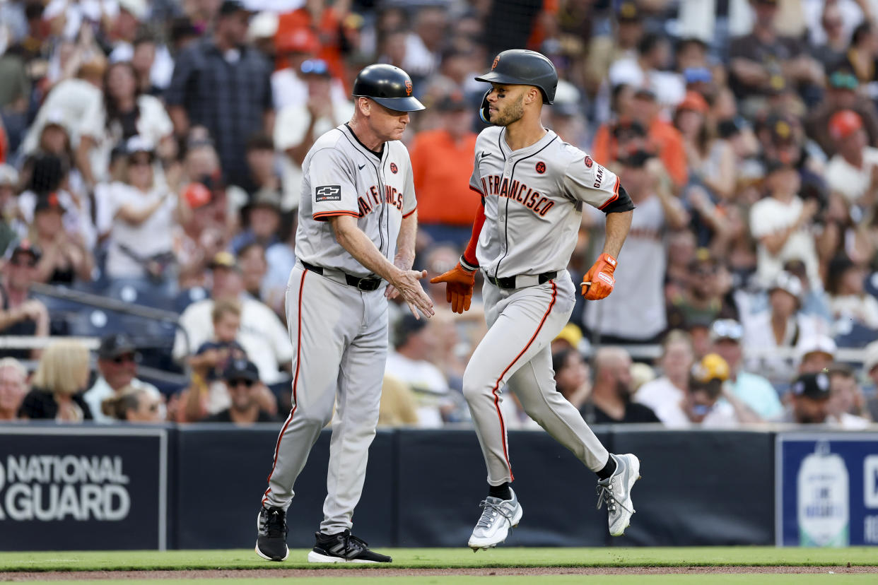 San Francisco Giants' Grant McCray, right, celebrates with third base coach Matt Williams, left, after hitting a three-run home run during the second inning of a baseball game against the San Diego Padres, Saturday, Sept. 7, 2024, in San Diego. (AP Photo/Ryan Sun)