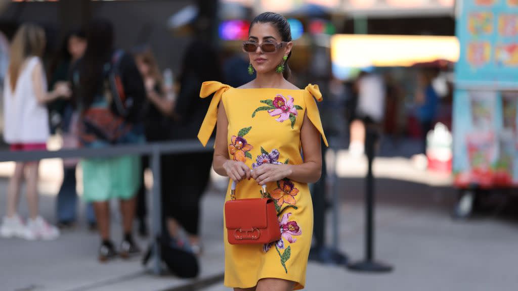 new york, new york september 12 a fashion week guest is seen wearing beige sunglasses from carolina herrera, green flower earrings, a sleeveless yellow mini dress with floral embroideries, an orange leather bag from carolina herrera before the carolina herrera spring summer 2024 runway show on september 12, 2023 in new york city photo by jeremy moellergetty images