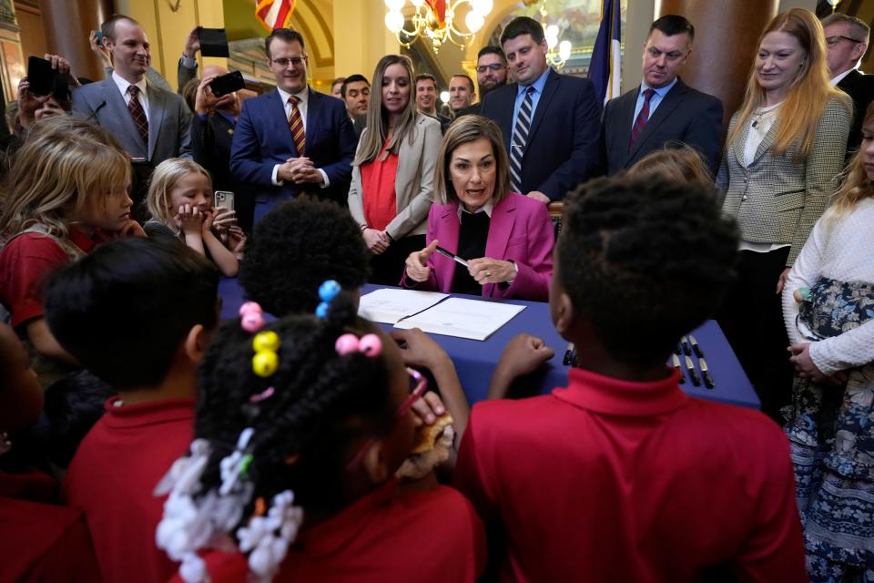 Iowa Gov. Kim Reynolds speaks to school children as she signs a bill that creates education savings accounts, Tuesday, Jan. 24, 2023, at the Statehouse in Des Moines, Iowa. Any Iowa student who wants to attend a private school could use public money to pay for tuition or other expenses under the plan approved early Tuesday by the Legislature, making the state the third to pass a measure that allows such spending with few restrictions. (AP Photo/Charlie Neibergall)