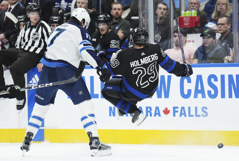 Winnipeg Jets forward Adam Lowry (17) checks Toronto Maple Leafs forward Pontus Holmberg (29) during the first period of an NHL hockey game in Toronto, Wednesday, Jan. 24, 2024. (Nathan Denette/The Canadian Press via AP)