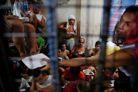 People at a detention cell enjoy their meal brought by a charity organisation to a police station in Manila, Philippines, October 7, 2016. REUTERS/Damir Sagolj/File Photo