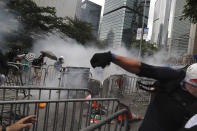 Protesters react to tear gas during a massive protest near the Legislative Council in Hong Kong, Wednesday, June 12, 2019. Thousands of protesters surrounded government headquarters in Hong Kong Wednesday as the administration prepared to open debate on a highly controversial extradition law that would allow accused people to be sent to China for trial.(AP Photo/Kin Cheung)