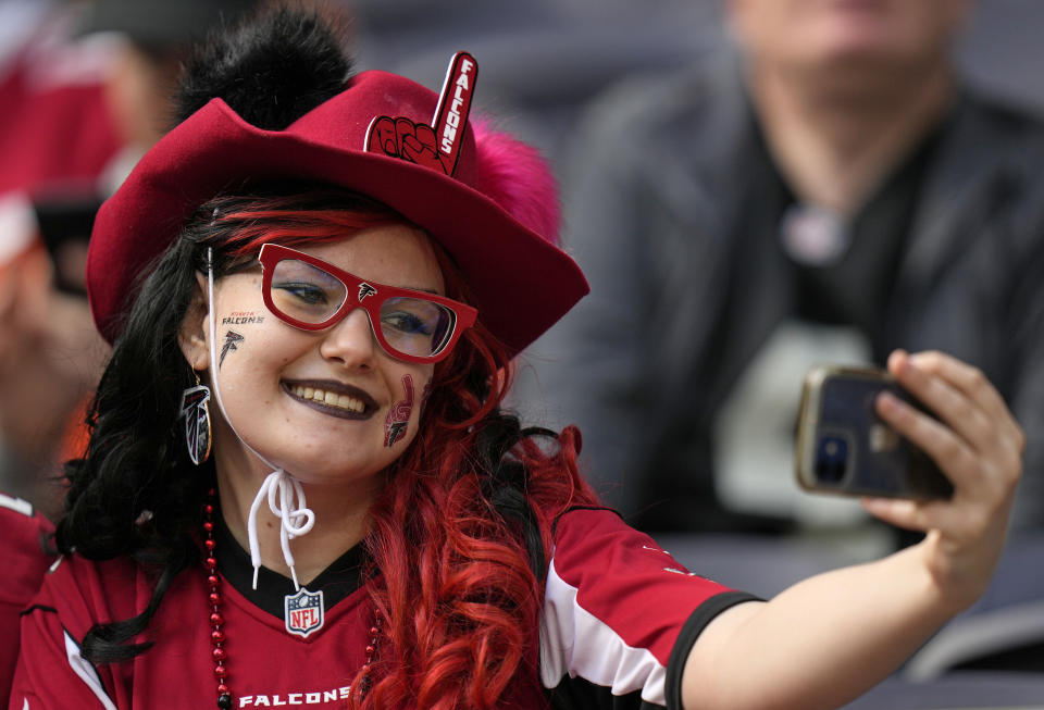 A Falcons fan takes a selfie before an NFL football game between the New York Jets and the Atlanta Falcons at the Tottenham Hotspur stadium in London, England, Sunday, Oct. 10, 2021. (AP Photo/Alastair Grant)