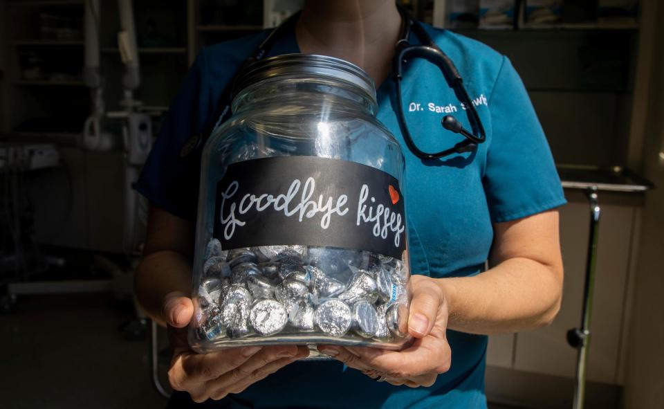 Associate veterinarian Sarah Sewick holds a jar of Hershey's Kisses labeled "Goodbye kisses" inside the Greenfield Animal Hospital in Southfield on Friday, Aug. 4, 2023.
