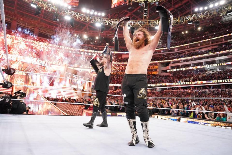 Kevin Owens and Sami Zayn hold up the WWE tag team titles after defeating The Usos at WrestleMania 39 at SoFi Stadium on Saturday, April 1, 2023. WWE