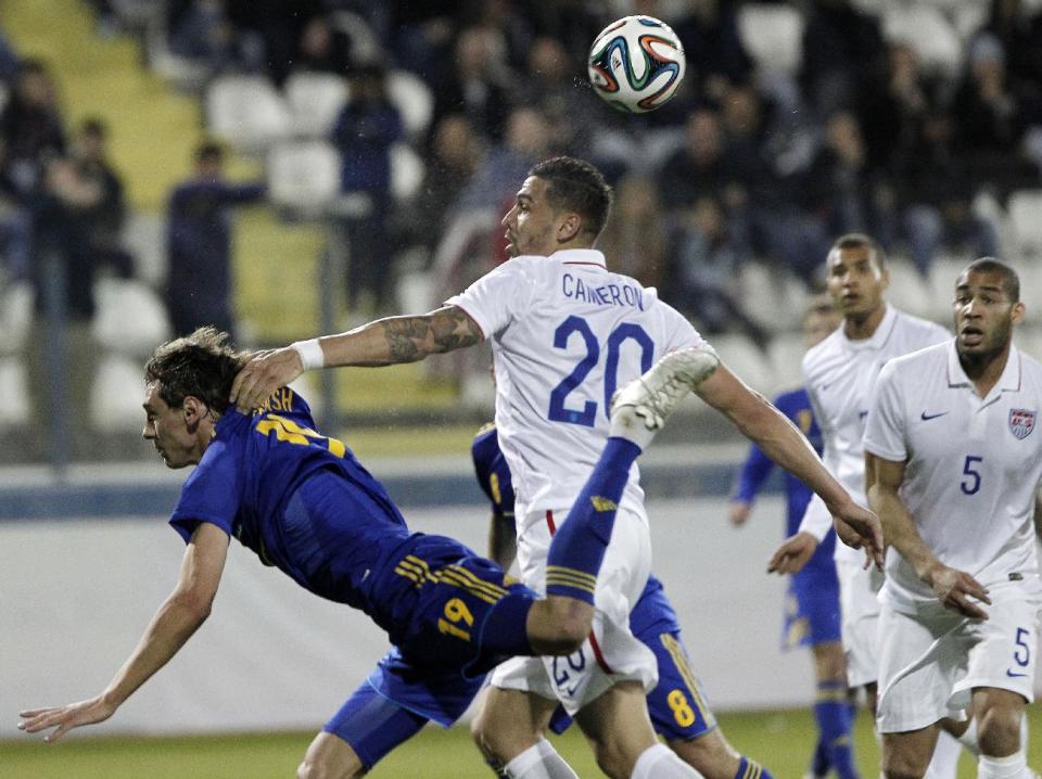 Ukraine's Denys Garmash, left, jumps for the ball with Geoff Cameron of the U.S. during an international friendly match at Antonis Papadopoulos stadium in southern city of Larnaca, Cyprus, Wednesday, March 5, 2014. The Ukrainians are face the United States in a friendly on Wednesday in Cyprus, a match moved from Kharkiv to Larnaca for security reasons. (AP Photo/Petros Karadjias)