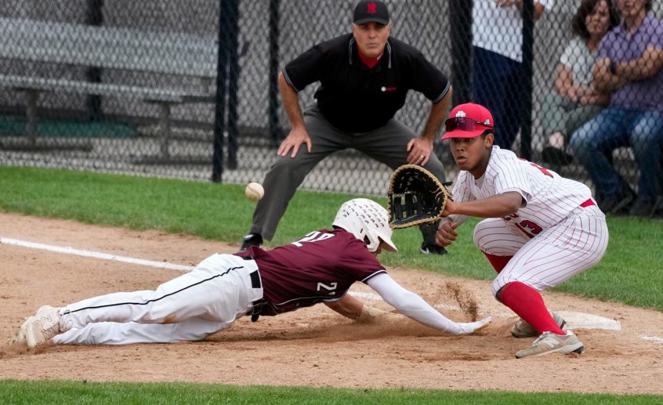 East Providence First baseman Ziurel Vargas waits for the throw as East Greenwich runner Robert Brooks dives safely back in the sixth inning. 