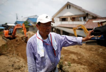63-year-old Atsushi Yamashita, who is living next to Odagawa River and Takama River, takes a break as he tries to remove mud and debris form his destroyed house in a flood affected area in Mabi town in Kurashiki, Okayama Prefecture, Japan, July 13, 2018. REUTERS/Issei Kato