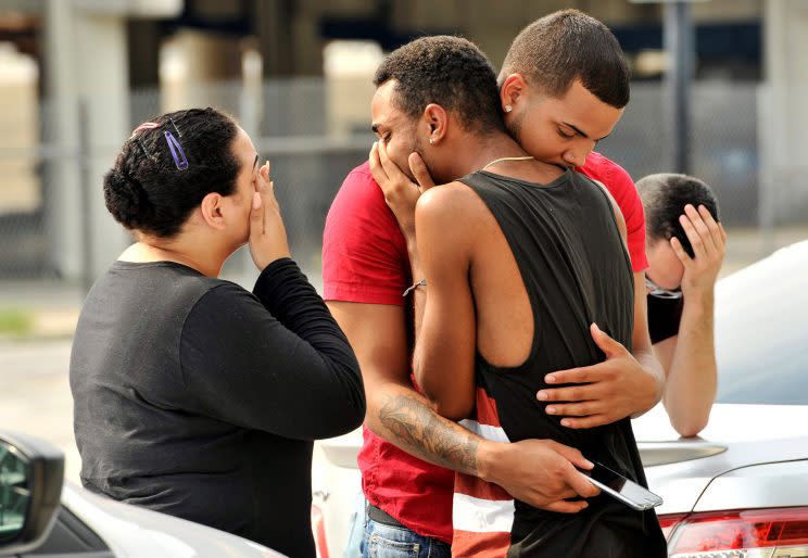 Friends and family members embrace outside the Orlando police headquarters on Sunday, after a mass shooting at the Pulse nightclub, which left at least 50 people dead. (Steve Nesius/Reuters)