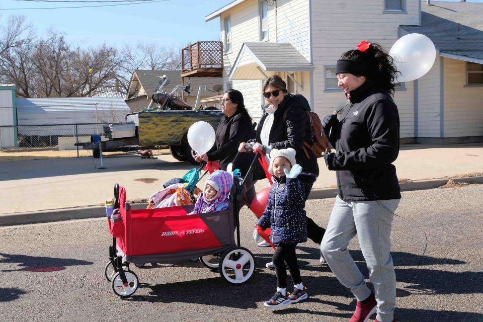 A family follows the Cat in the Hat Saturday at Storybridge's “Cat in the Hat March” celebrating Read across America in Amarillo.