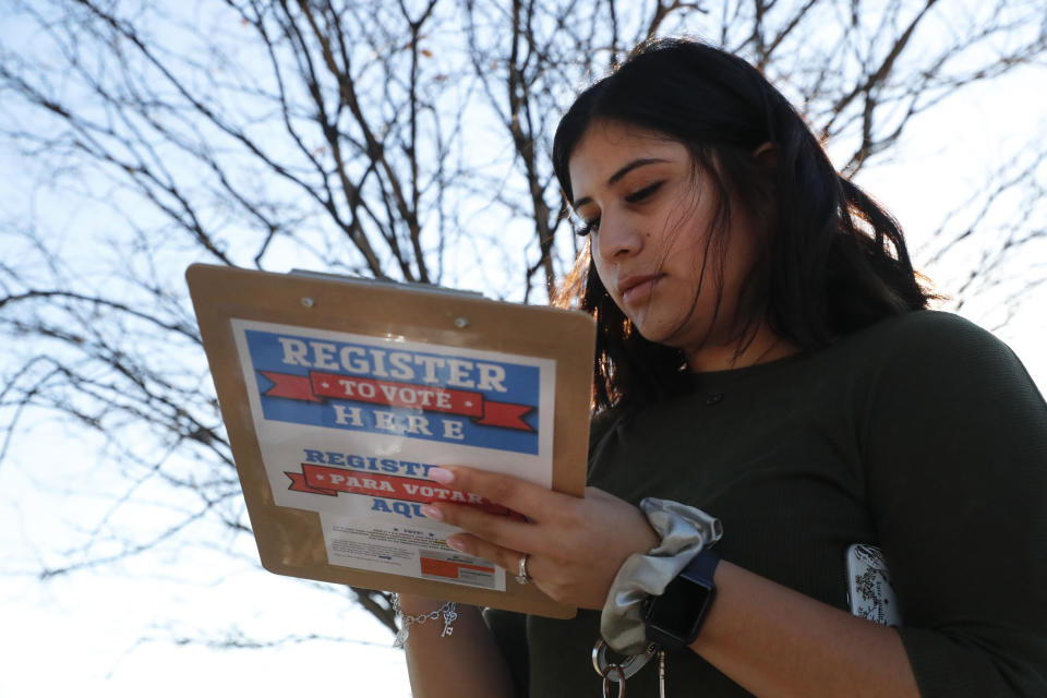 Karina Shumate, 21, a college student studying stenography, fills out a voter registration form in Richardson, Texas, Saturday, Jan. 18, 2020. Democrats are hoping this is the year they can finally make political headway in Texas and have set their sights on trying to win a majority in one house of the state Legislature. Among the hurdles they'll have to overcome are a series of voting restrictions Texas Republicans have implemented in recent years, including the nation's toughest voter ID law, purging of voter rolls and reductions in polling places. (AP Photo/LM Otero)