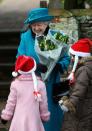 <p>Queen Elizabeth smiles as she receives flowers from young well-wishers on Christmas Day.</p>