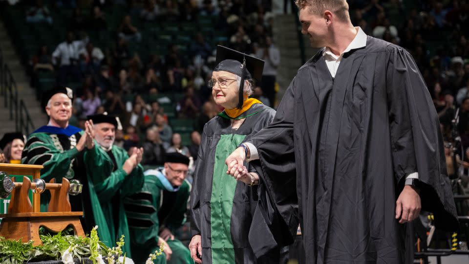 Minnie Payne, 90, is escorted across the stage by her grandson, Payne Billings. - Courtesy Ahna Hubnik/University of North Texas