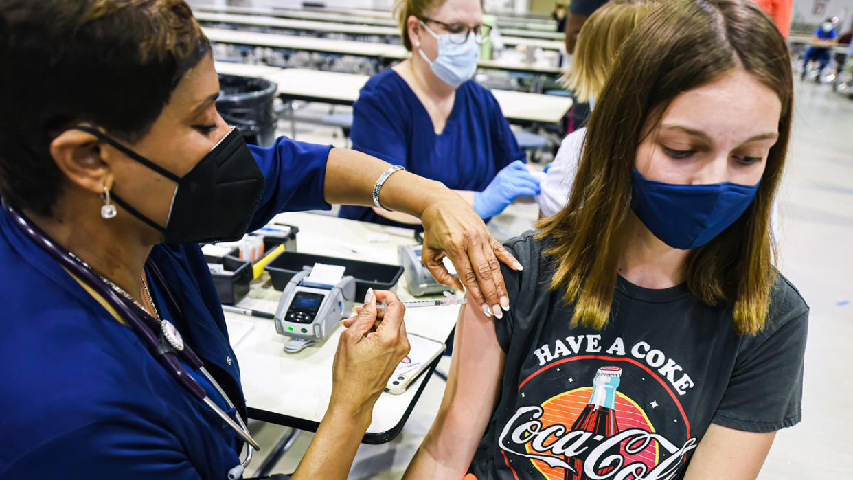 A nurse administers the Pfizer vaccine at a COVID-19 clinic at Lyman High School in Longwood, Fla., on the day before classes begin for the 2021-22 school year.  
