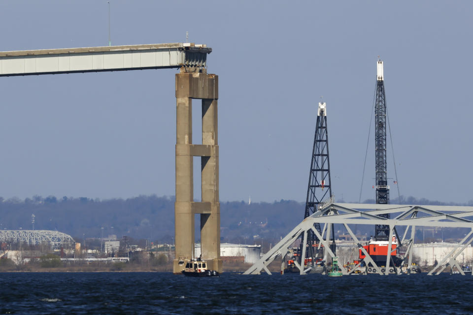 Cranes stand by as the wreckage of the Francis Scott Key Bridge rests on the container ship Dali, Saturday, March 30, 2024, in Baltimore. (AP Photo/Julia Nikhinson)