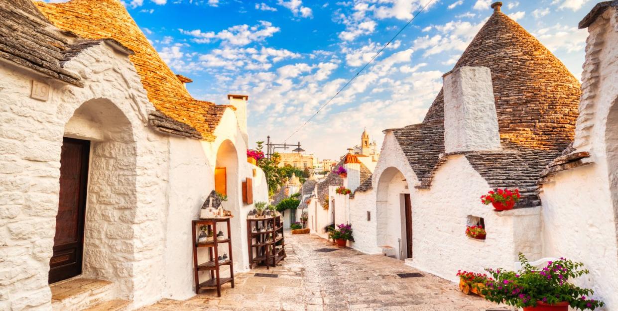 famous trulli houses during a sunny day with bright blue sky in alberobello, puglia, italy