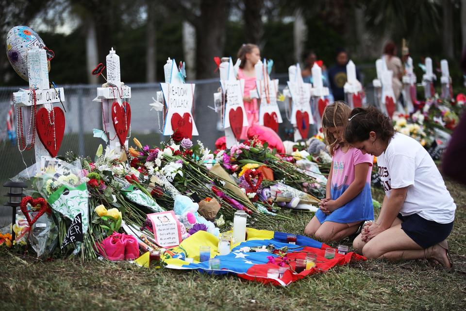 People visit a makeshift memorial setup in front of Marjory Stoneman Douglas High School on Feb. 19, 2018 in Parkland, Florida.