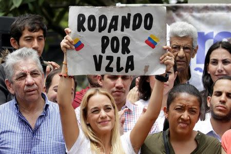 Lilian Tintori (C), wife of jailed Venezuelan opposition leader Leopoldo Lopez, holds a placard reading "Rolling through Venezuela" during a gathering with opposition supporters in wheelchairs who arrived from the state of Lara in Caracas, Venezuela August 31, 2016. REUTERS/Marco Bello