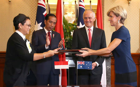 Indonesian Minister for Foreign Affairs Retno Marsudi (L) exchanges documents with Australian Foreign Minister Julie Bishop during a signing ceremony as Indonesian President Joko Widodo (2nd L) and Australian Prime Minister Malcolm Turnbull watch on at Admiralty House in Sydney, Australia, February 26, 2017. REUTERS/David Moir/Pool