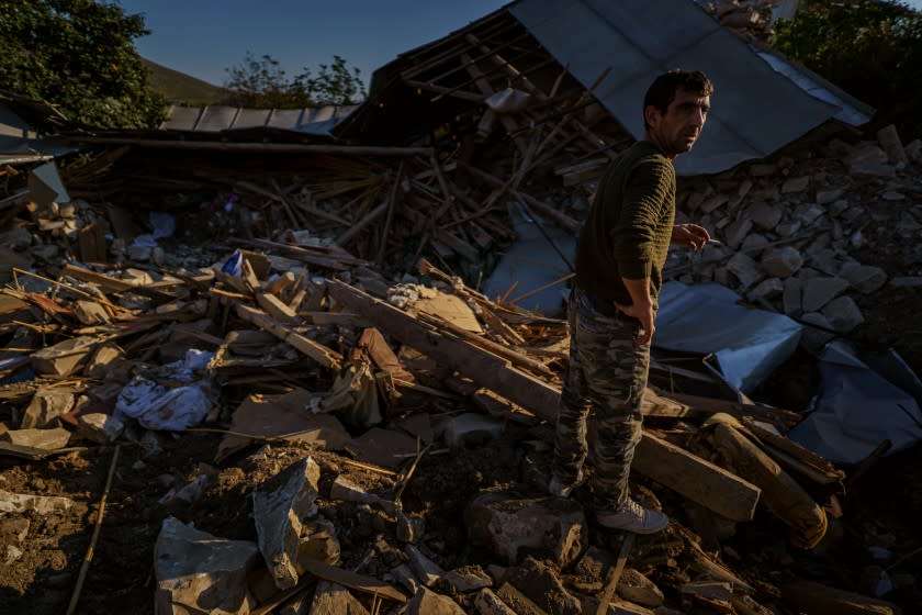 A man looks over a wreckage of a home destroyed by a military strike in Martuni, Nagorno-Karabakh.